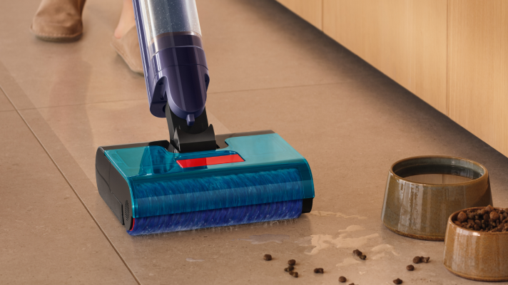 Woman vacuuming living room floor with Dyson vacuum